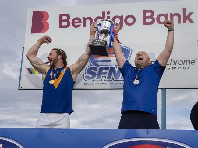 Cranbourne captain Brandon Osborne and coach Steve O’Brien lift the premiership cup. Picture: Valeriu Campan