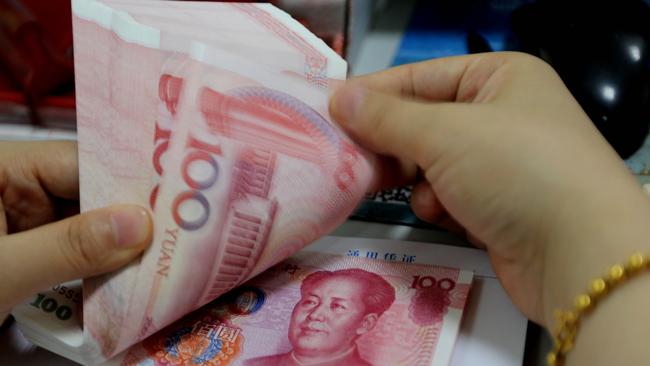 A teller counts yuan banknotes in a bank in Lianyungang, east China's Jiangsu province on August 11, 2015. China's central bank on August 11 devalued its yuan currency by nearly two percent against the US dollar, as authorities seek to push market reforms and bolster the world's second-largest economy. CHINA OUT AFP PHOTO