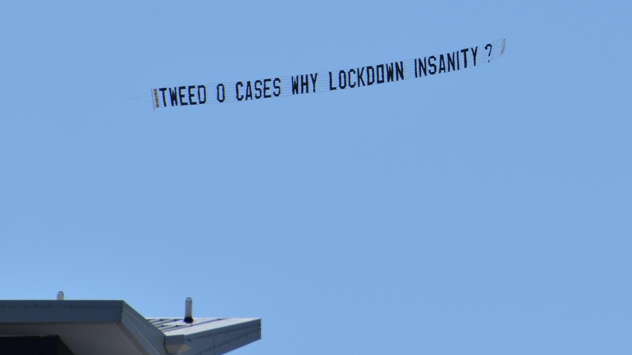 A plane flies over with a sign that says ‘Tweed 0 cases why lockdown insanity’. Photo: Liana Walker