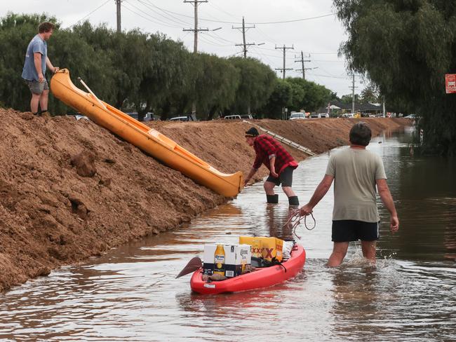 Canoes and tinnies have become essential in flooded streets. Picture: David Caird