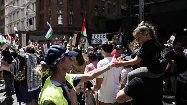 A police officer and a young girl share a friendly interaction during a pro-Palestine rally and march starting in Hyde Park and Marching through the streets of Sydney CBD. Picture: Dylan Robinson