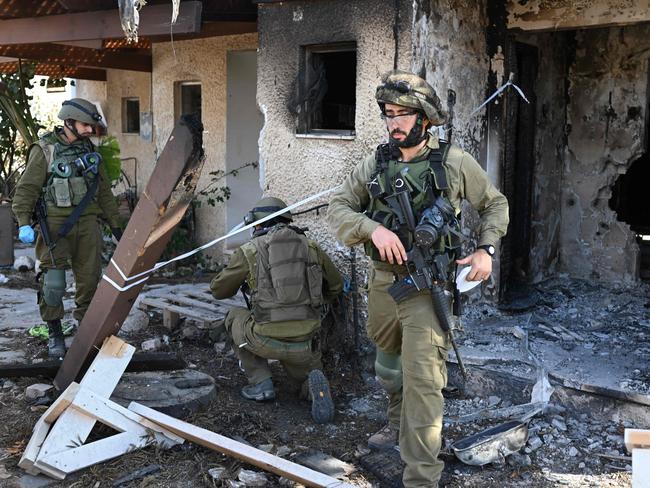 Israeli soldiers cordon off an area in Kibbutz Beeri near the border with the Gaza Strip on October 15, 2023, after the October 7 attack by Palestinian militants. In the eight days since Hamas gunmen killed more than 1,300 Israelis in a surprise attack, Israel has responded with a bombing campaign that has claimed over 2,300 lives in Gaza. (Photo by YURI CORTEZ / AFP)