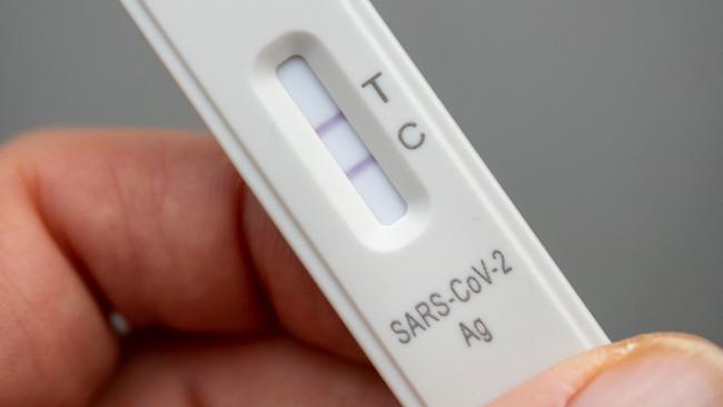 A used rapid antigen test, also known as a lateral flow test showing a positive test result for the Covid-19 coronavirus is photographed in Berlin on January 22, 2022. - Taking a test involves doing swab from inside your nostril or in your throat, depending on the test you are using, before mixing the swab with solution and dripping it onto a container with a test strip with antibodies specific to the Covid-19 virus painted on it in a thin line. If the testing strip detects the virus, it shows up as a red line next to the âTâ on the container, the line next to the âCâshould always be visible. (Photo by Odd ANDERSEN / AFP)