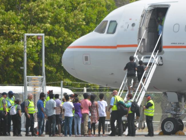 Asylum seekers prepare to board a plane at Cocos Island to fly to the Curtin Detention Centre in Western Australia. Picture: