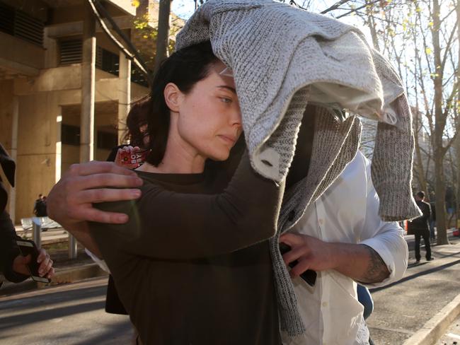 Sarah Budge tries to cover her face to avoid the media. Picture: Richard Dobson