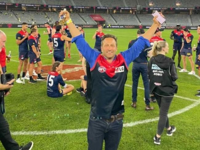 Hayden Burbank on the ground at Optus Stadium after the Demons won the AFL Grand Final.