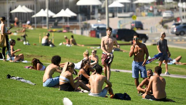 Young tourists on the grass at Bondi Beach in Sydney on Tuesday. Picture: AAP