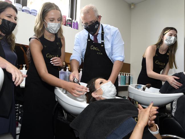 Prime Minister Scott Morrison washing a customer’s hair at Coco's Hair Salon in Melbourne. Picture: NCA NewsWire/Andrew Henshaw