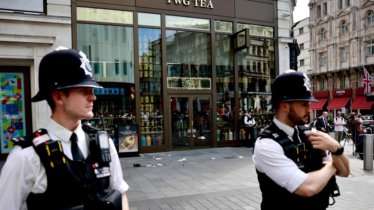 Police officers standing by a cordoned off area in Leicester Square, London. A woman and an 11-year-old girl were hospitalised after a stabbing attack. (Photo by BENJAMIN CREMEL / AFP)