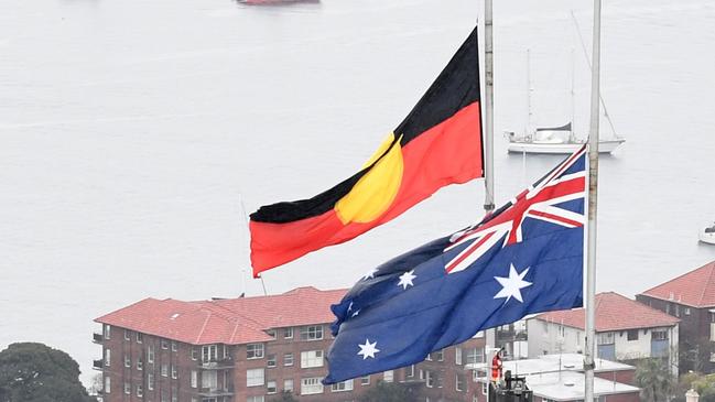 The Australian national flag and the Aboriginal flag are seen at half mast on Sydney Harbour Bridge as a sign of respect for the passing of Queen Elizabeth II on September 9. Now Byron will wrestle with the decision of what to do on January 26. Picture: James D. Morgan/Getty Images