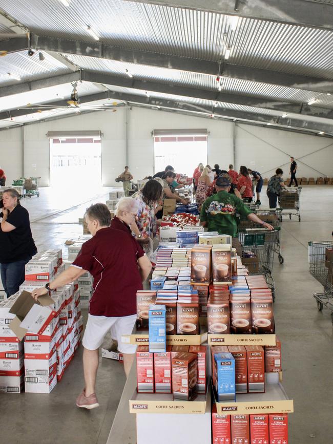 CHRISTMAS SPIRIT: Dozens of volunteers either loaded boxes or made sure the food supplies on offer were ready for packaging.