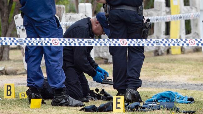 Police forensics officers examine the officers’ gun at the scheme. Picture: Julian Andrews