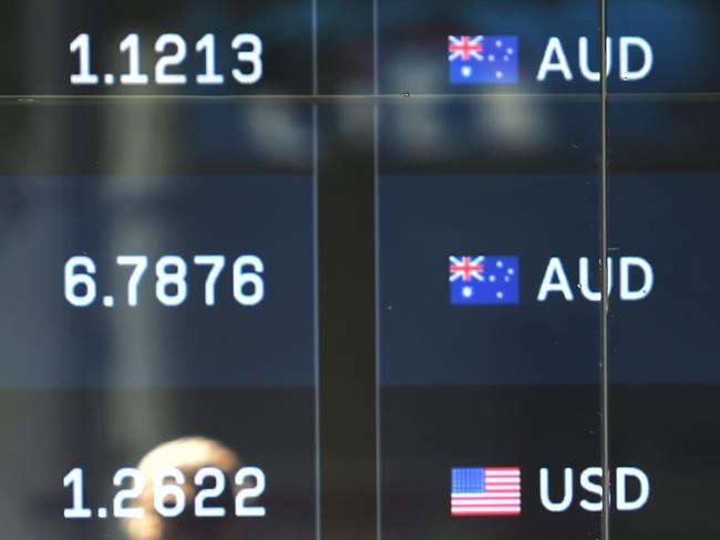 A pedestrian passes by currency prices on display at a bank on a street in Sydney on October 7, 2014. The Australian dollar hit a four-year-low of 86.43 US cents in New York last week as Australia's economy struggles to transition away from resources-led growth following an unprecedented boom in mining investment that is expected to fall-off sharply over the next year. AFP PHOTO/Peter PARKS