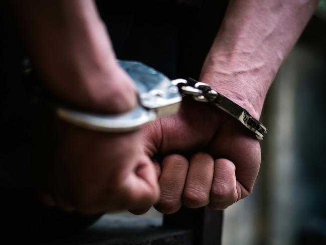 Man on the chair in Handcuffs. Rear view and Closeup ,Men criminal in handcuffs arrested for crimes. With hands in back,boy  prison shackle in the jail violence concept.