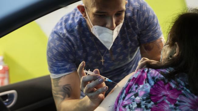 A health worker administers a COVID-19 vaccine to a person in a car at an underground carpark in Santiago, Chile. Picture: Getty Images