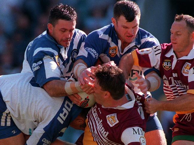 Dean Pay (middle Bulldog) crunches Glenn Lazarus.