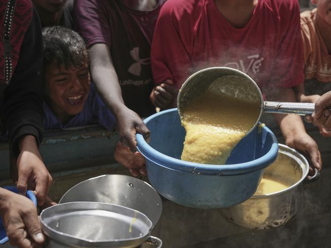 Palestinian children struggle to get donated food at a community kitchen in Khan Younis, southern Gaza Strip, Thursday April 24, 2025.(AP Photo/Abdel Kareem Hana)