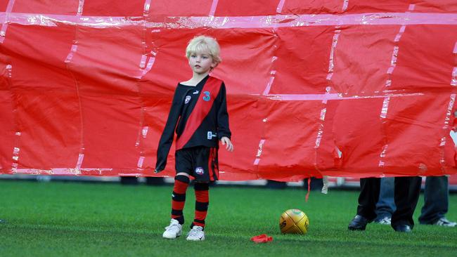 A six-year-old Tom Hird waits for his dad on the MCG. 