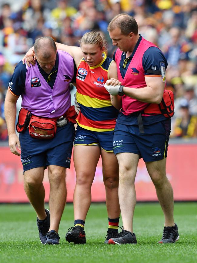 Crows youngster Chloe Scheer is helped off the ground by team medics during the AFLW grand final against Carlton Blues after injuring her knee. Picture: AAP Image/David Mariu