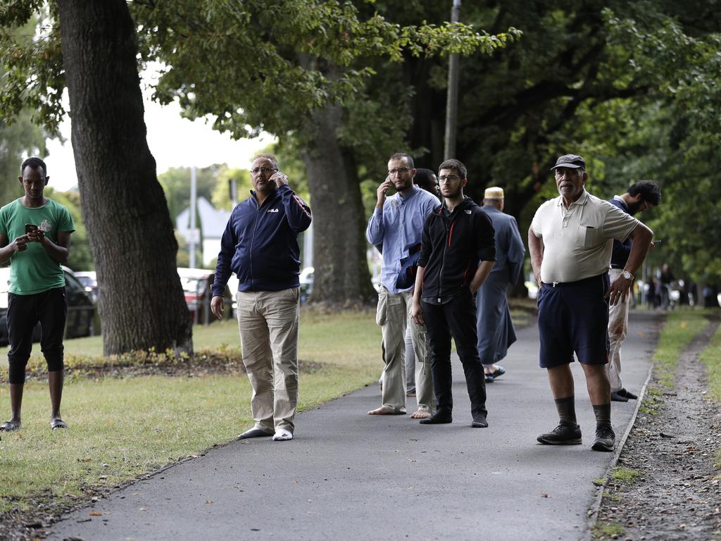 People wait outside across the road outside a mosque in central Christchurch, New Zealand, Friday, March 15, 2019. (AP Photo/Mark Baker)