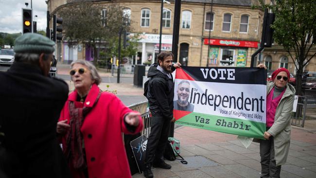 Campaigners calling for an end to the war in Gaza hold a flag promoting Vaz Shabir, an independent candidate in the UK general election. Picture: Oli Scarff/AFP