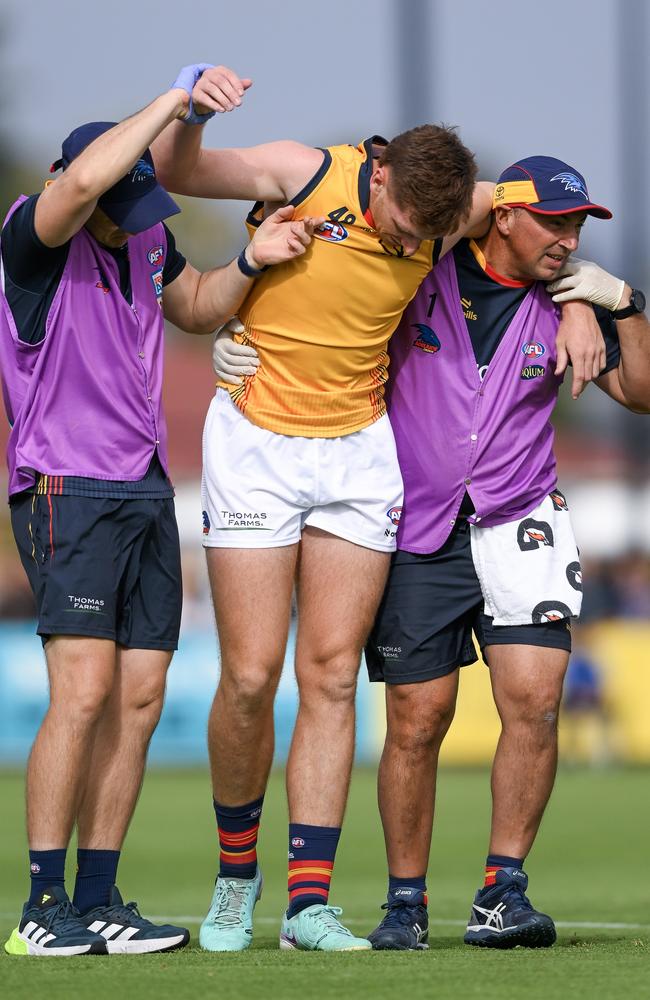 Crows player Mark Keane is helped off by trainers after a concussion during a practice match this year. Picture: Getty Images