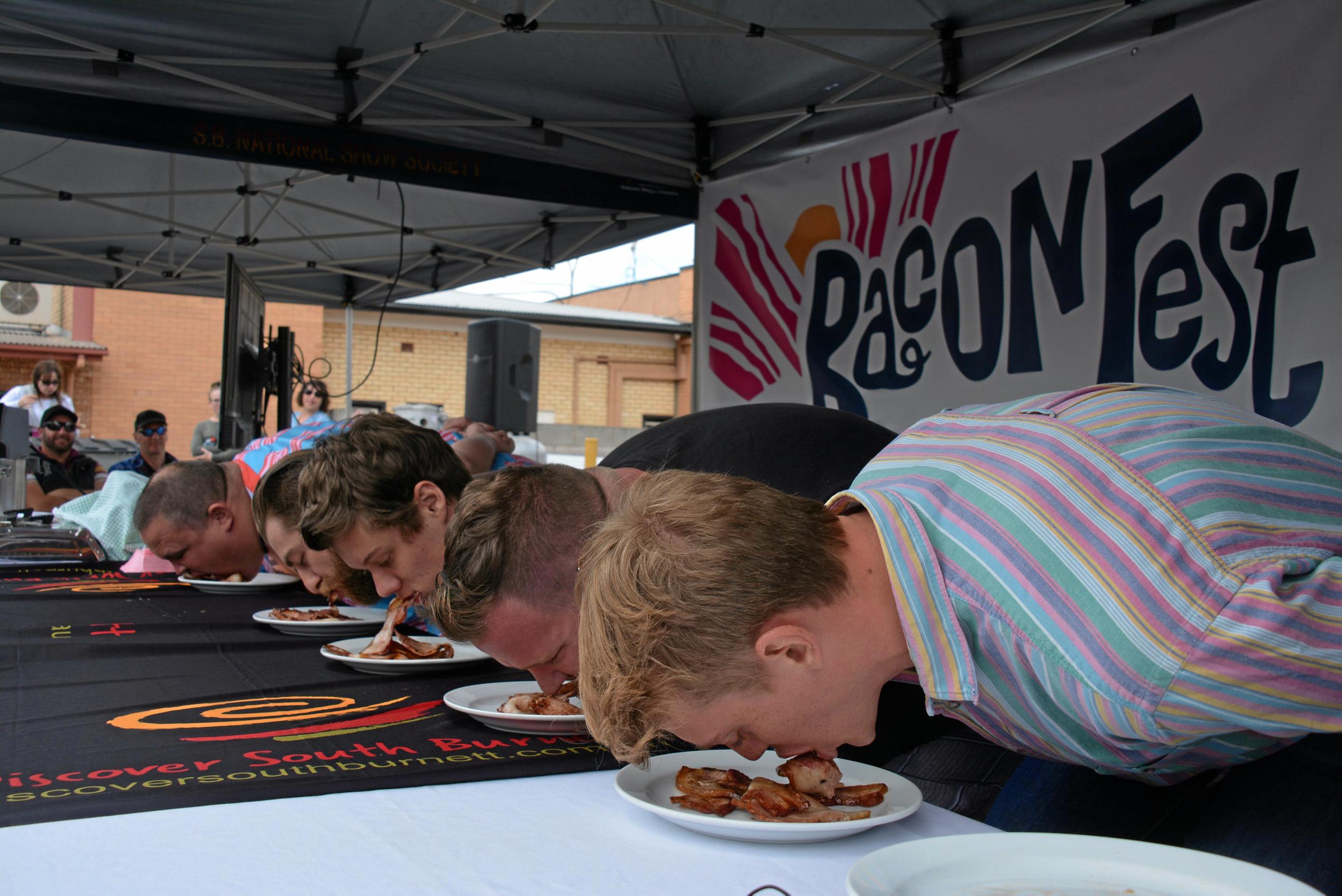 Competitors fight for the top spot at the bacon eating competition during Kingaroy's BaconFest on Saturday August 25. Picture: Jessica McGrath