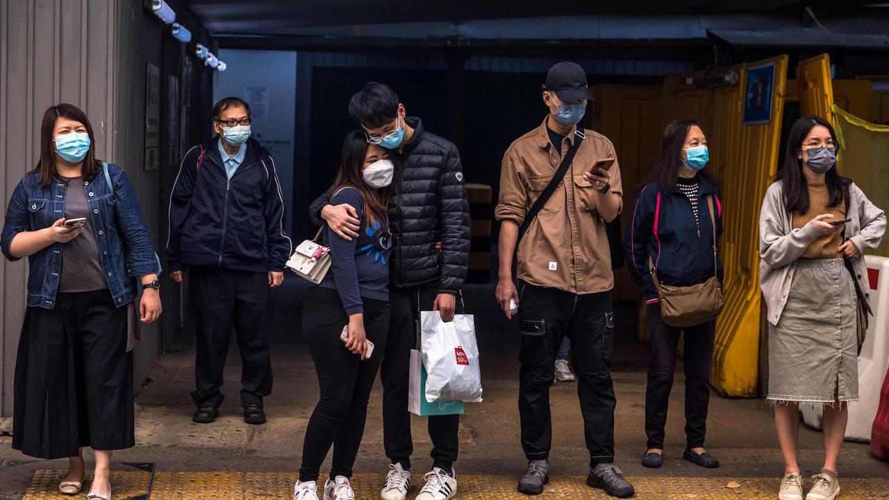 People wait to cross a street in Hong Kong, which has suspend it court system due to Covid. Picture: AFP.