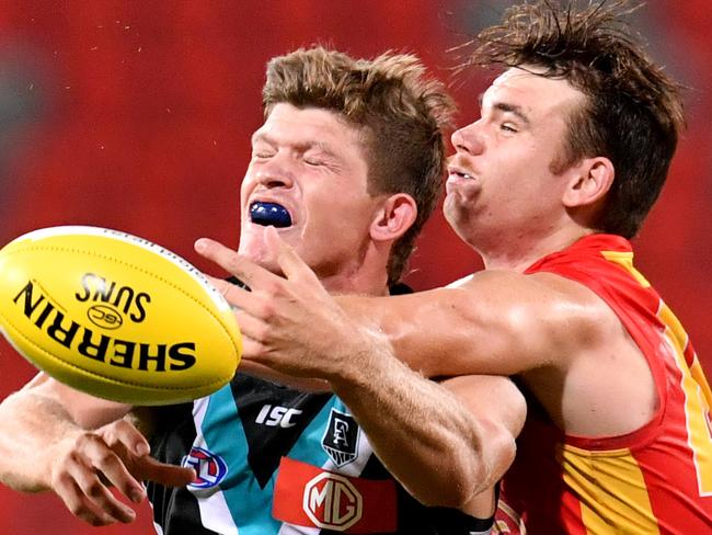 Mitch Georgiades (left) of the Power in action during the Round 1 AFL match between the Gold Coast Suns and Port Adelaide Power at Metricon Stadium on the Gold Coast, Saturday, March 21, 2020. (AAP Image/Darren England) NO ARCHIVING, EDITORIAL USE ONLY