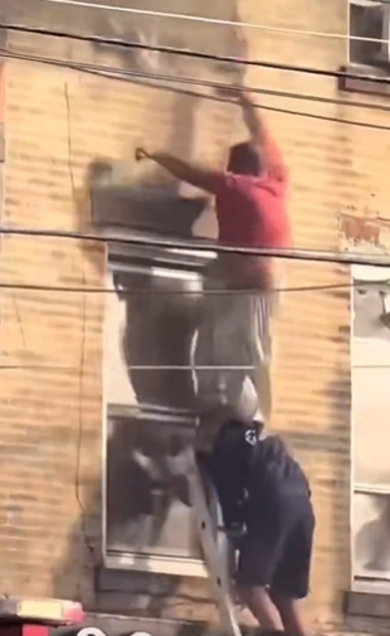 The firefighter who was atop the ladder was able to maintain his grip. Picture: X@dom_lucre