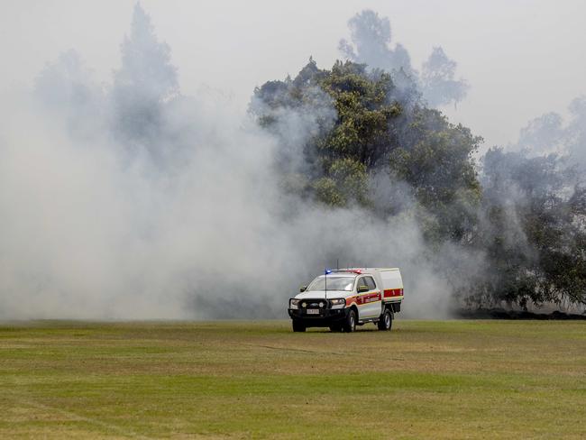 Smoke haze covers the Gold Coast Skyline from a grass fire at Carrara. Emergency services at St Michael's Collage, Merrimac. Picture: Jerad Williams