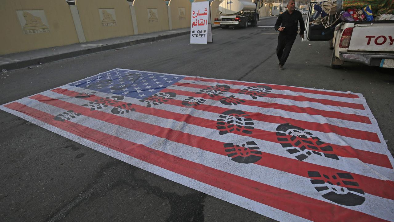 A mock US flag is laid on the ground for cars to drive on in the Iraqi capital of Baghdad on January 3 following the air strike. Picture: AHMAD AL-RUBAYE / AFP.