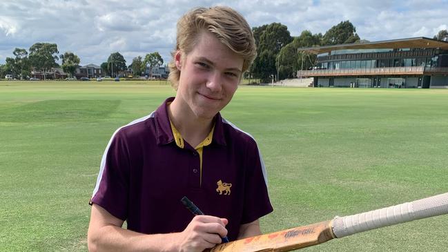 Josh Walker signs a bat, a Wesley College tradition, after one of his centuries.