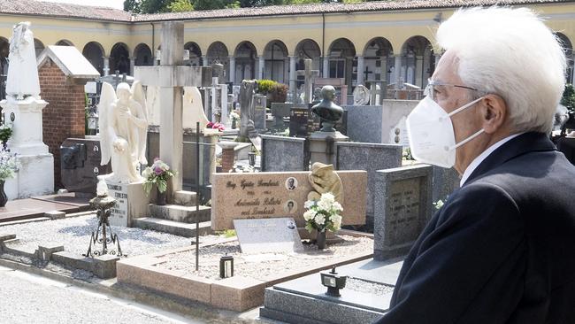 Italian President Sergio Mattarella stands silent in front of graves, at the cemetery of Codogno, where Italy's first local case of coronavirus was confirmed in February. Picture: Italian Presidency via AP