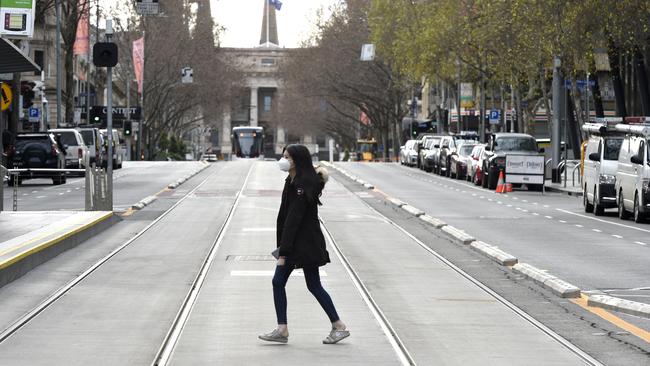 A woman walks across Bourke Street in the Melbourne CBD on Monday. Picture: Andrew Henshaw