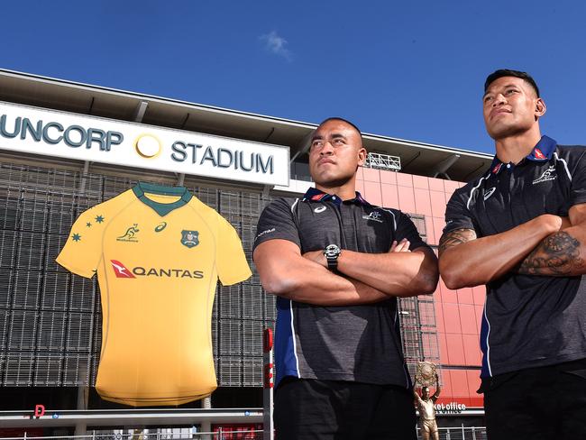 Caleb Timu and Israel Folau pose for a photograph at Suncorp Stadium with the backdrop of a giant Wallabies jersey.Sunday June 3, 2018. (AAP image, John Gass)