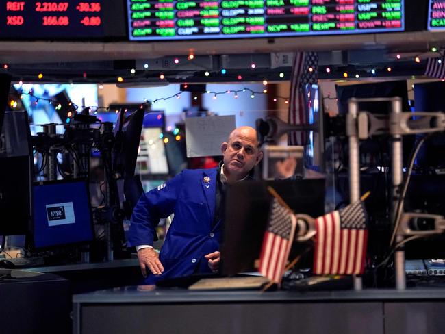 A trader reacts on the floor of the New York Stock Exchange at the closing bell on December 30, 2022 in New York. - Wall Street stocks marked a gloomy end to 2022, slumping to close lower in their worst annual showing in years. Surging inflation and steep interest rate hikes to cool demand have battered markets and investor sentiment this year, on top of global shocks like Russia's invasion of Ukraine. (Photo by TIMOTHY A. CLARY / AFP)