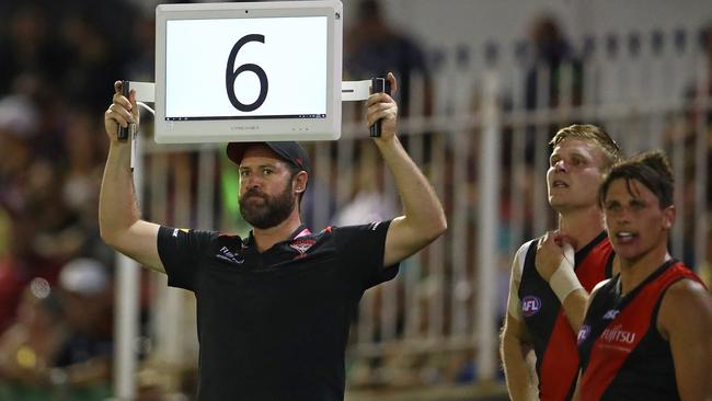 An Essendon official holds up an electric sign.