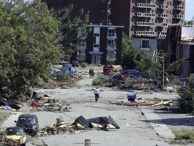 People walk past debris in a Gatineau, Quebec, Canada. Picture: Fred Chartrand/The Canadian Press via AP