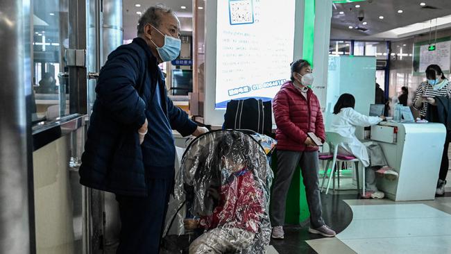 A man waits with an ill child at the hospital. Picture: AFP