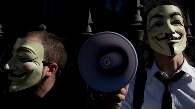 People wearing masks often used by a group that calls itself 'Anonymous' take part in a rally in Madrid, Spain, 15/05/2011 file photo. Spanish police arrested three suspected computer hackers that allegedly belonged to a loose-knit international activist group that has attacked corporate and government websites around the world.