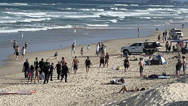 Three people are being assessed by paramedics after being pulled from the water at Main Beach. Picture: Lea Emery