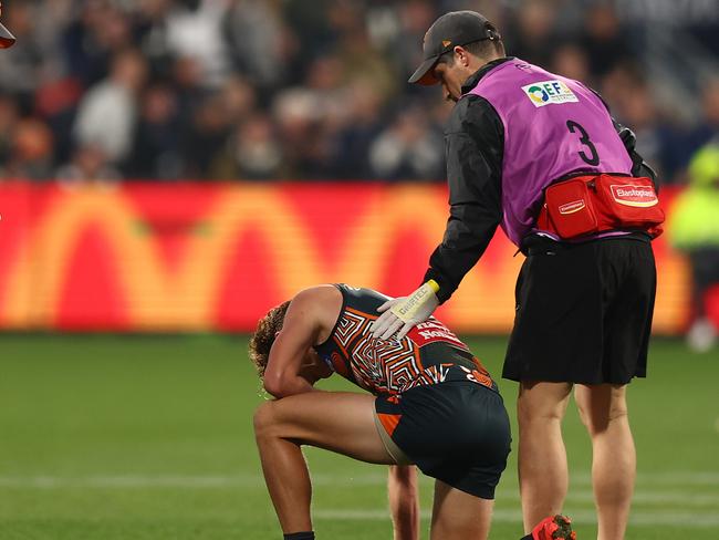 Lachie Whitfield in the hands of trainers. (Photo by Graham Denholm/Getty Images)