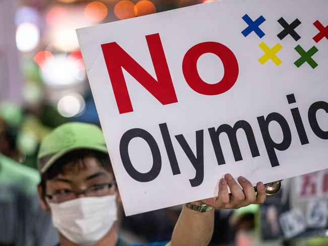 An anti-Olympic activist holds up a placard with a slogan reading "No Olympics" during a march to the offices of the Tokyo Organising Committee of the Olympic and Paralympic Games. (Photo by Philip FONG / AFP)