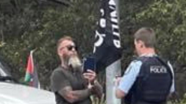 A man is under investigation after he was charged for refusing a drug test while allegedly carrying a Palestinian flag and a black flag with white Arabic text.