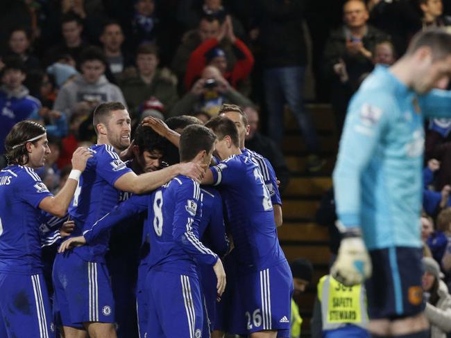 Chelsea players congratulate Chelsea's Brazilian-born Spanish striker Diego Costa (C) after Costa scored their second goal during the English Premier League football match between Chelsea and Hull City at Stamford Bridge in London on December 13, 2014. AFP PHOTO / JUSTIN TALLIS RESTRICTED TO EDITORIAL USE. No use with unauthorized audio, video, data, fixture lists, club/league logos or “live” services. Online in-match use limited to 45 images, no video emulation. No use in betting, games or single club/league/player publications.