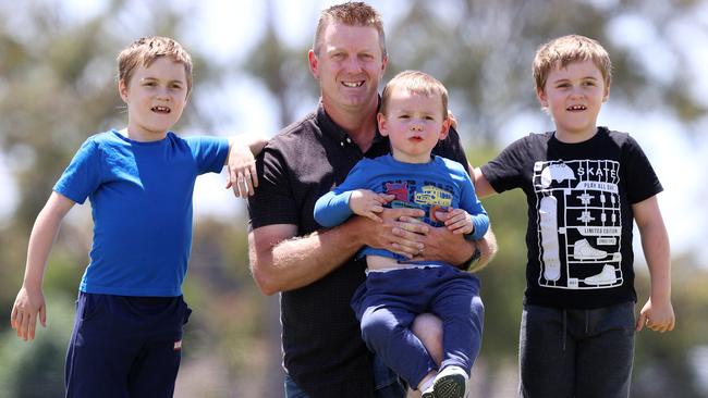 Travis McCarty with twins Cooper and Riley, 7, and little brother Logan, 2, who all suffer from Duchenne muscular dystrophy. Picture: Michael Klein