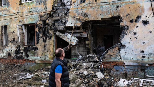 Andryi Pleshan, 60, checks destruction around his shelter in the occupied city of Izium, eastern Ukraine.