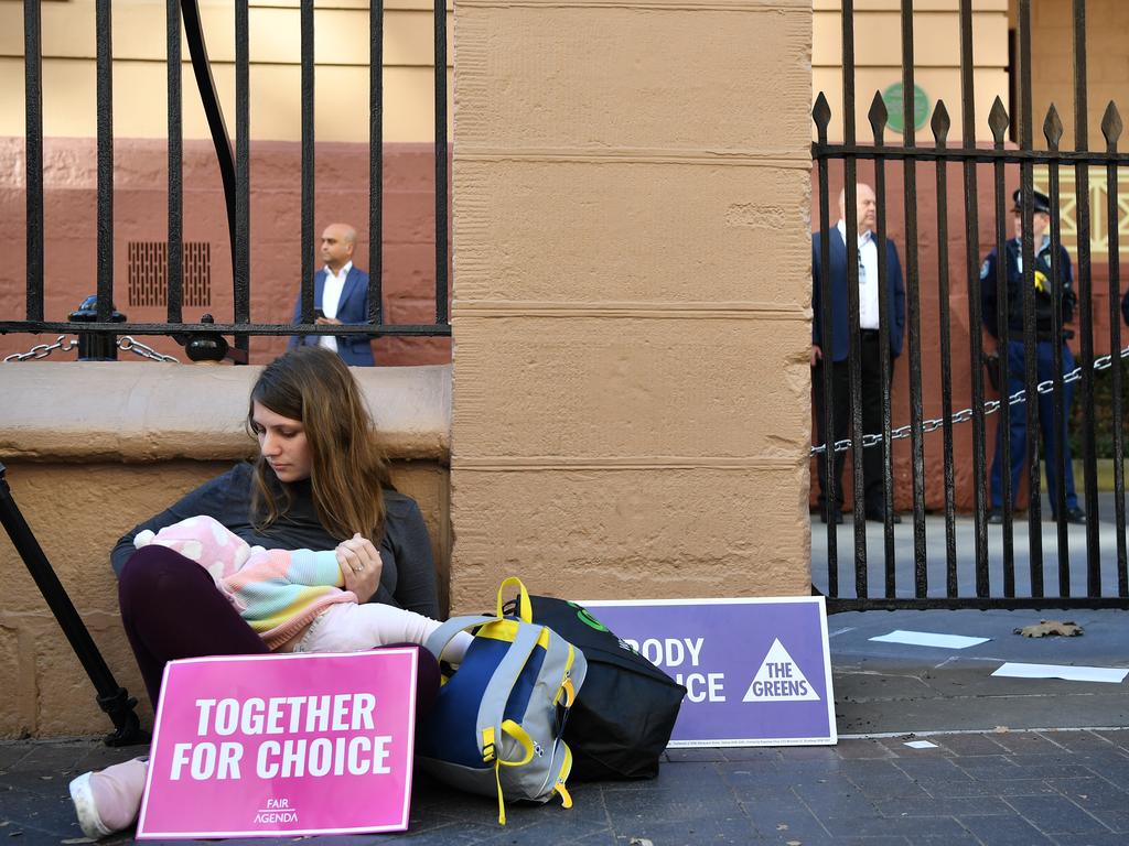 A Pro-choice advocate seen with her baby during a rally outside the New South Wales Parliament house in Sydney, Tuesday, August 6, 2019. (AAP Image/Joel Carrett)