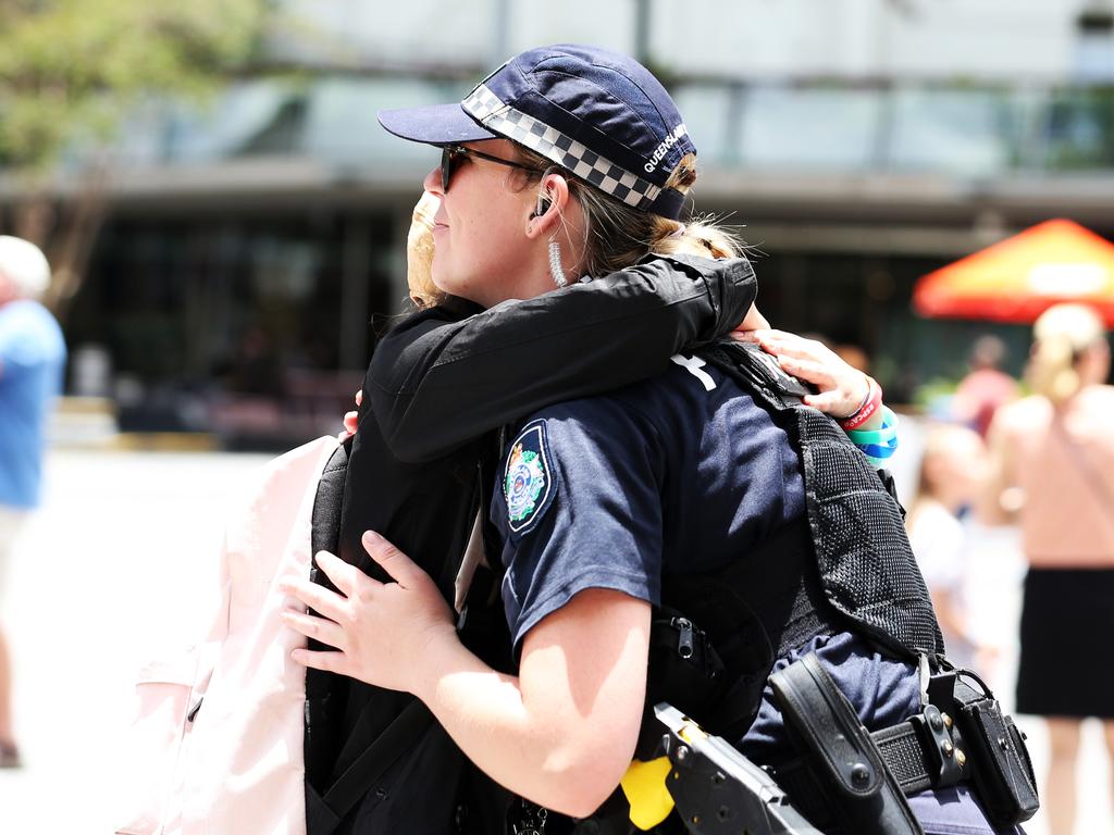 A member of the Queensland police service receives a hug from a member of the public after watching the Queensland Police Memorial Service for Constable Rachel McCrow and Constable Matthew Arnold from King George Square. Picture: Zak Simmonds